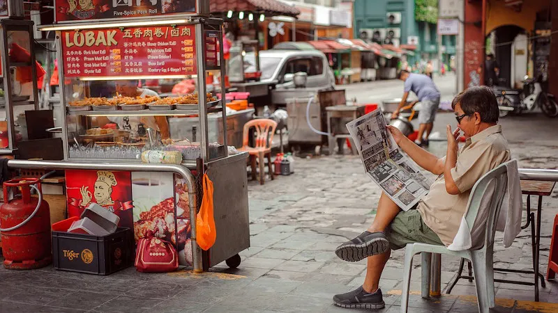 a Malaysian man reads newspaper
